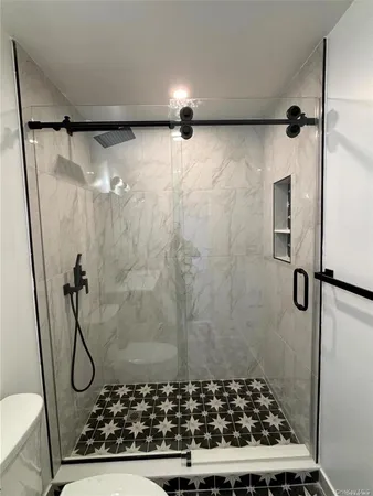 a bathroom with a granite countertop shower and a rug