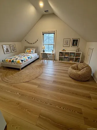 a bedroom with a bed and wooden floor