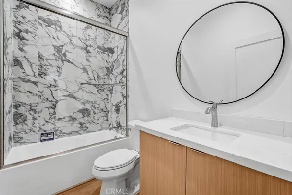 a bathroom with a sink toilet and a mirror