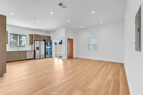 a view of an empty room with closet and a window