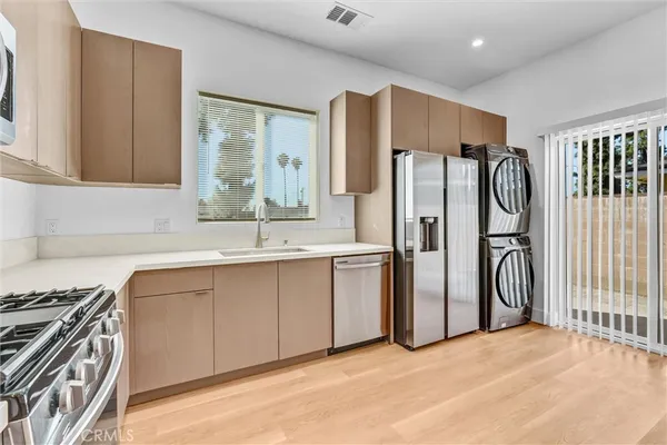 a kitchen with stainless steel appliances granite countertop a refrigerator and a sink