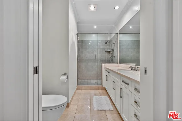 a bathroom with a granite countertop sink a toilet a mirror and shower