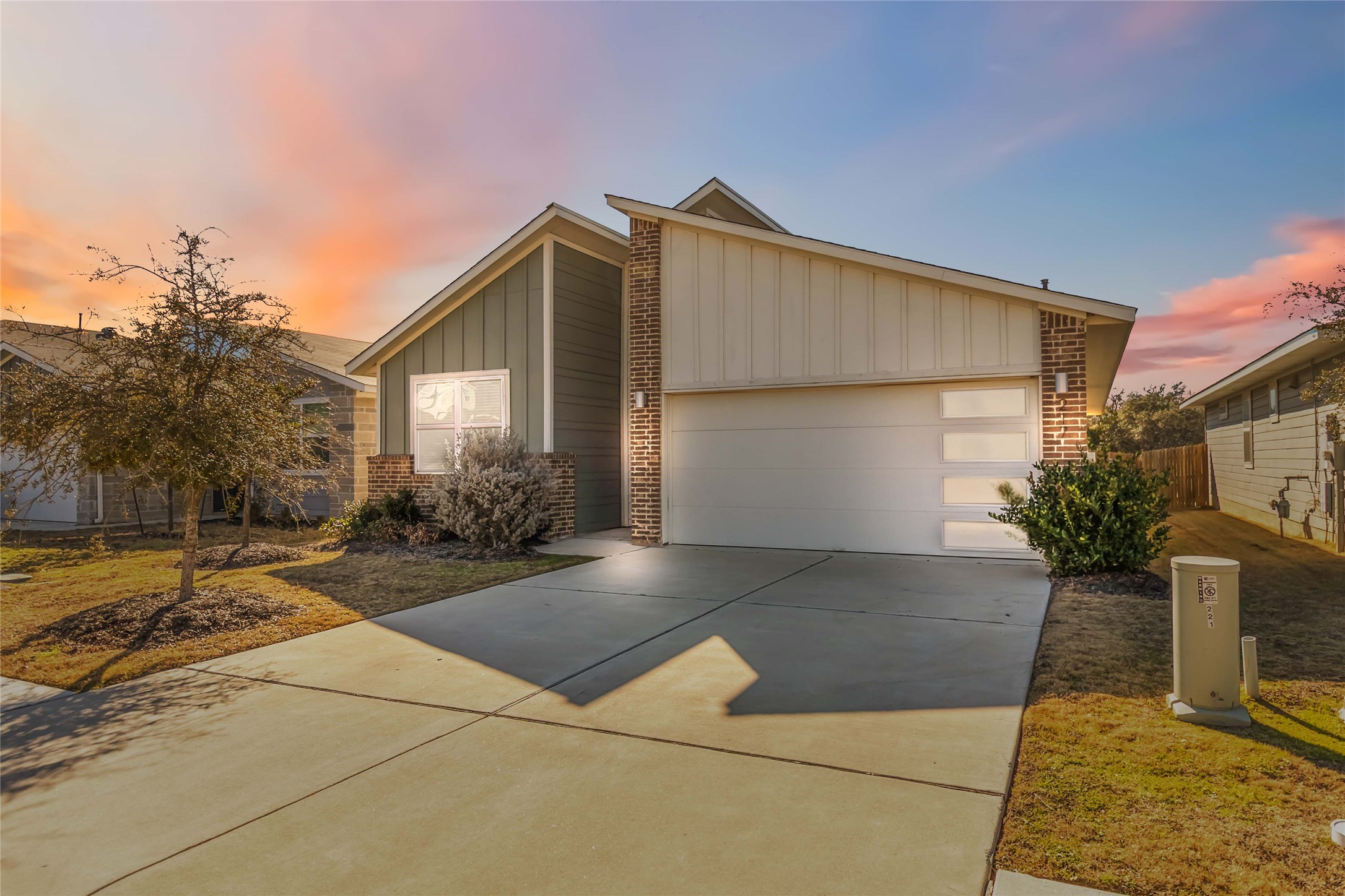 217 Deserti Road Leander, TX 78641 - Photo 1 of 1 View of front facade with board and batten siding, brick siding, driveway, and a garage