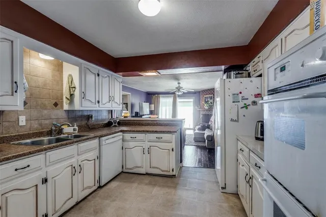 a kitchen with white cabinets and white appliances