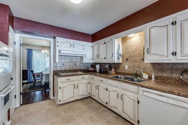 a kitchen with granite countertop a sink stove and cabinets