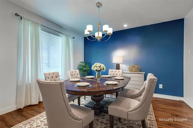 a view of a dining room with furniture a chandelier and wooden floor