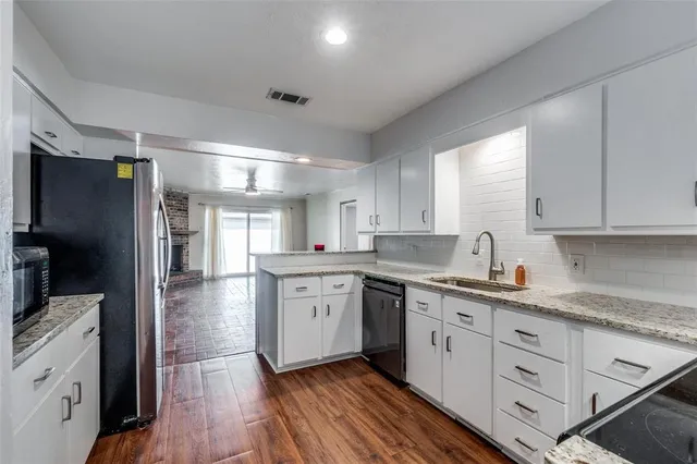 a kitchen with white cabinets and stainless steel appliances