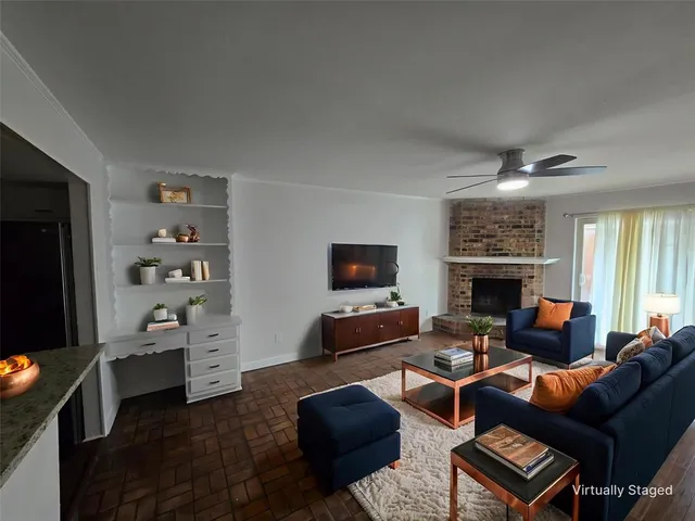 a living room with furniture a flat screen tv and a fireplace