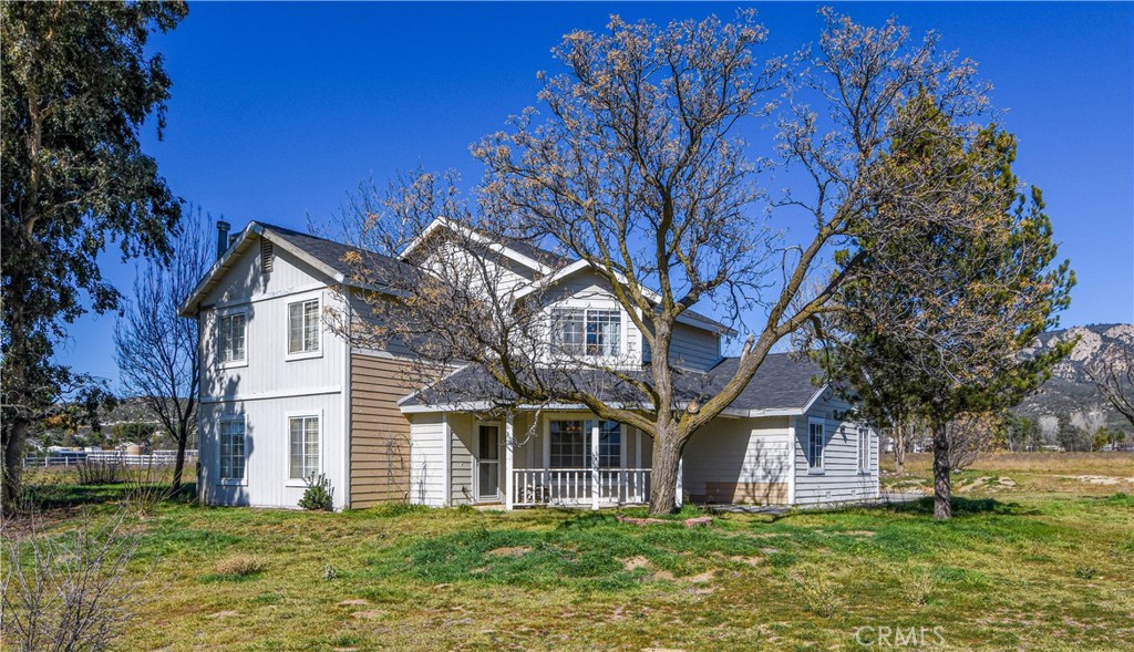 a front view of a house with a garden and trees