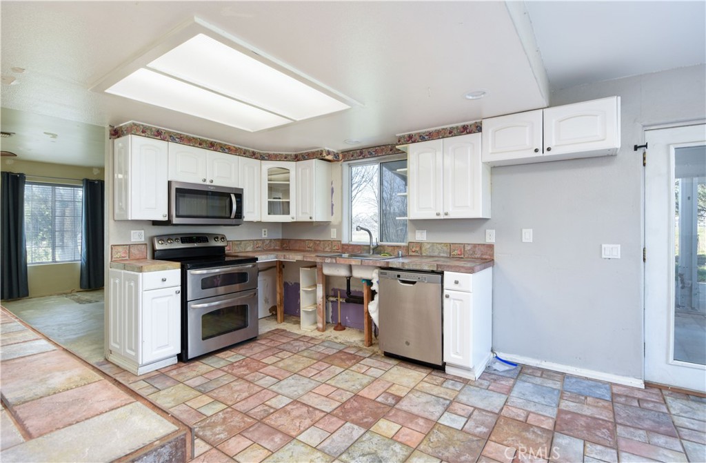 40520 Lake Riverside Drive Aguanga, CA 92536 - Photo 9 of 36 a kitchen with granite countertop a stove top oven a sink dishwasher and a refrigerator