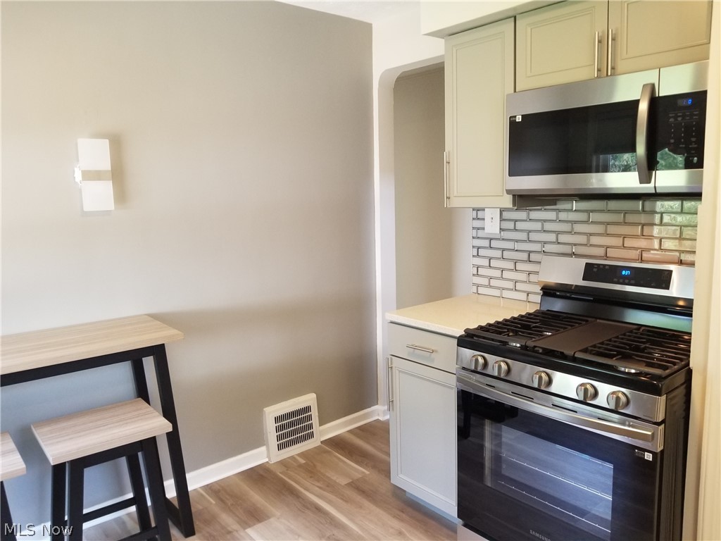 5671 Wellington Road Cleveland, OH 44124 - Photo 6 of 26 Kitchen with decorative backsplash, light hardwood / wood-style flooring, and appliances with stainless steel finishes