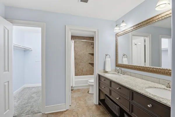 a spacious bathroom with a granite countertop sink mirror and shower