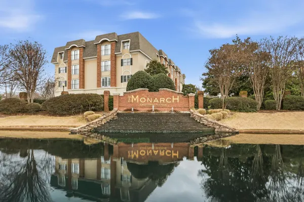 a front view of a house with a yard and lake view