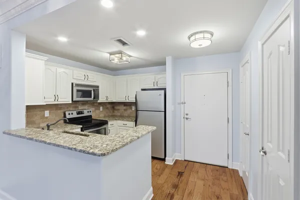 a kitchen with stainless steel appliances granite countertop a refrigerator and a sink