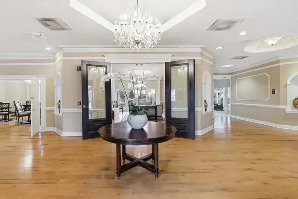 a living room with dining table and a chandelier