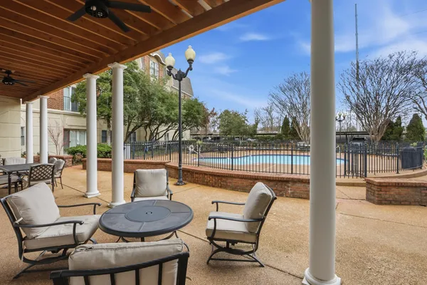 a balcony with wooden floor table and chairs