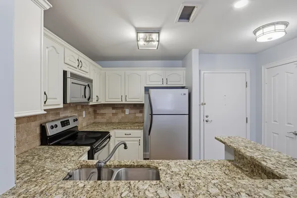 a kitchen with a refrigerator sink and stove