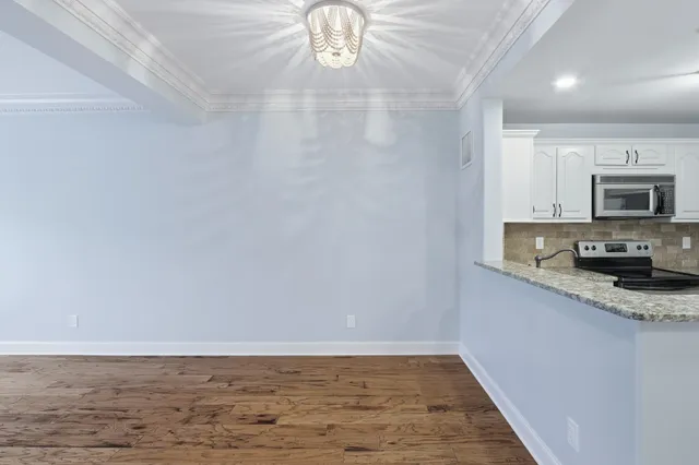 a view of kitchen with granite countertop cabinets and sink