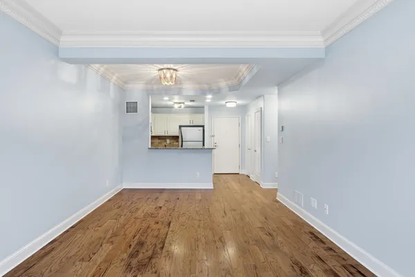 a view of a big room with wooden floor and windows
