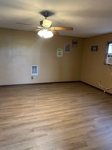 a view of a room with wooden floor and fan
