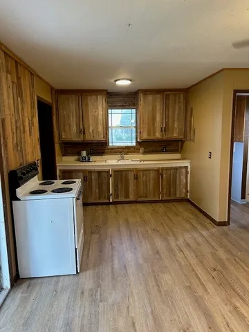 a kitchen with wooden floors and wooden cabinets