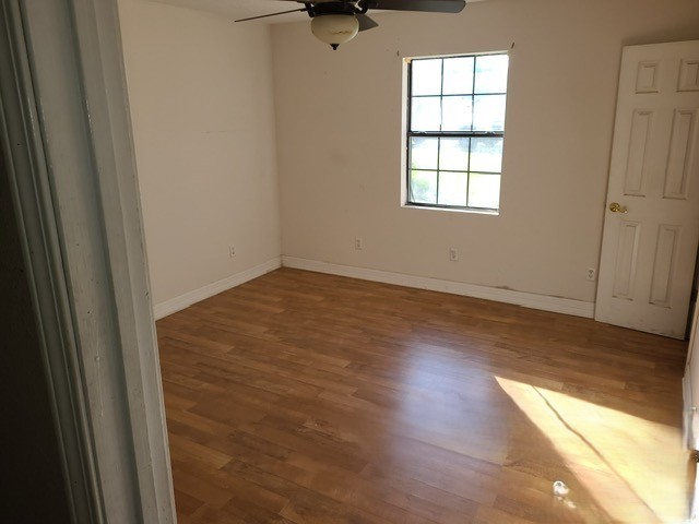21788 Interstate 10 Vidor, TX 77662 - Photo 12 of 14 an empty room with wooden floor cabinet and windows