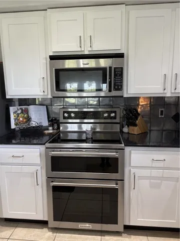 a stove top oven sitting inside of a kitchen