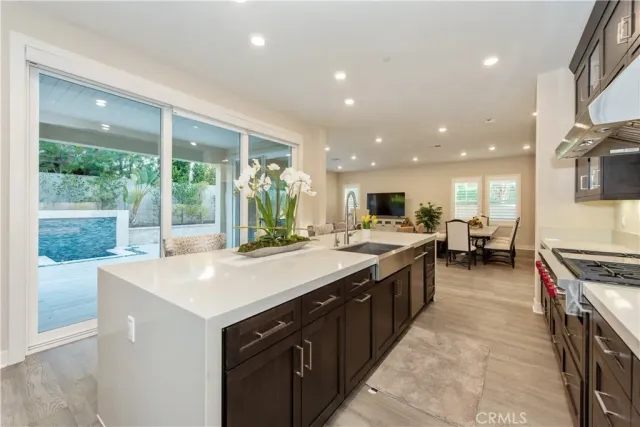 a kitchen with stainless steel appliances a table and chairs in it