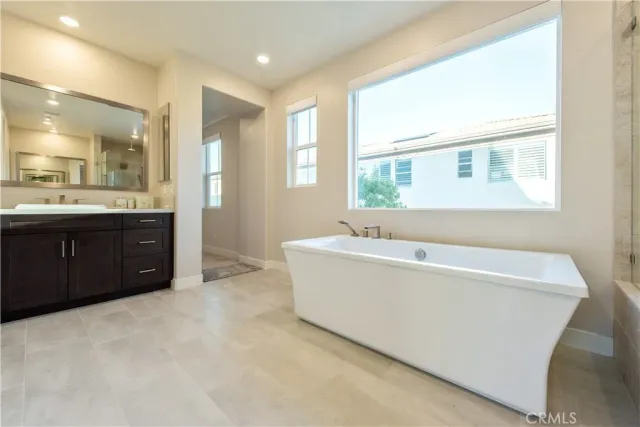 a bathroom with a tub sink shower and mirror