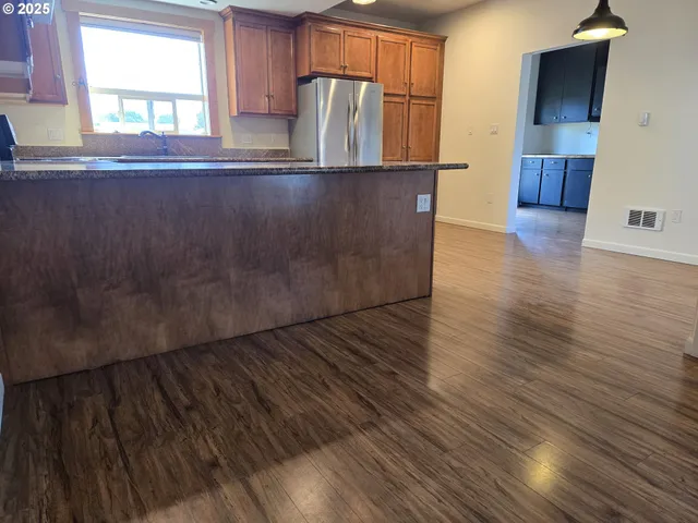 a view of kitchen with wooden floor and electronic appliances