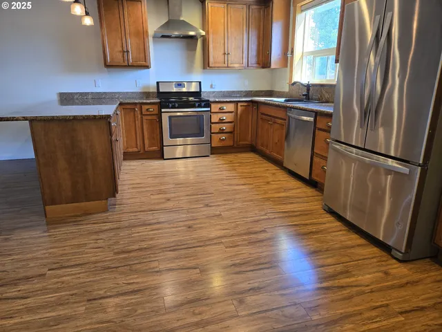 a kitchen with granite countertop a refrigerator and a sink