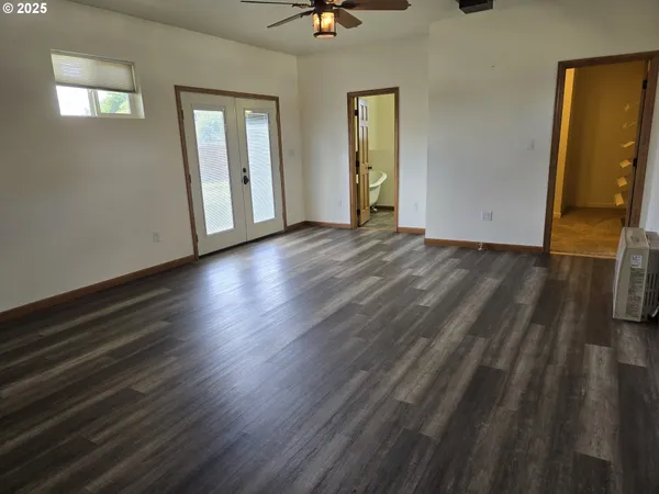 a view of a livingroom with wooden floor and a ceiling fan