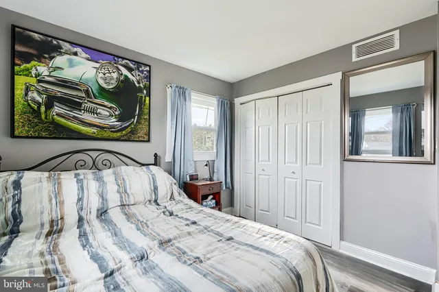 a bedroom with a bed and painting on the wall