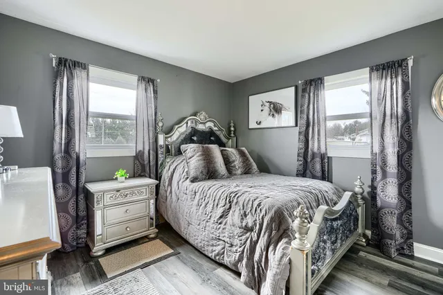 a bedroom with a bed and large windows