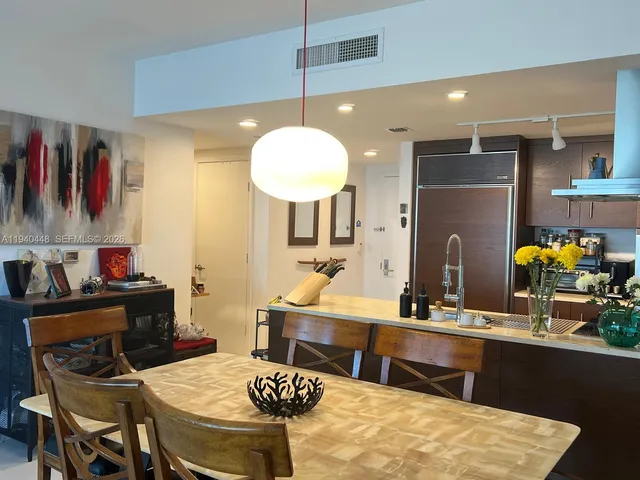 a room with stainless steel appliances kitchen island a table and chairs in it