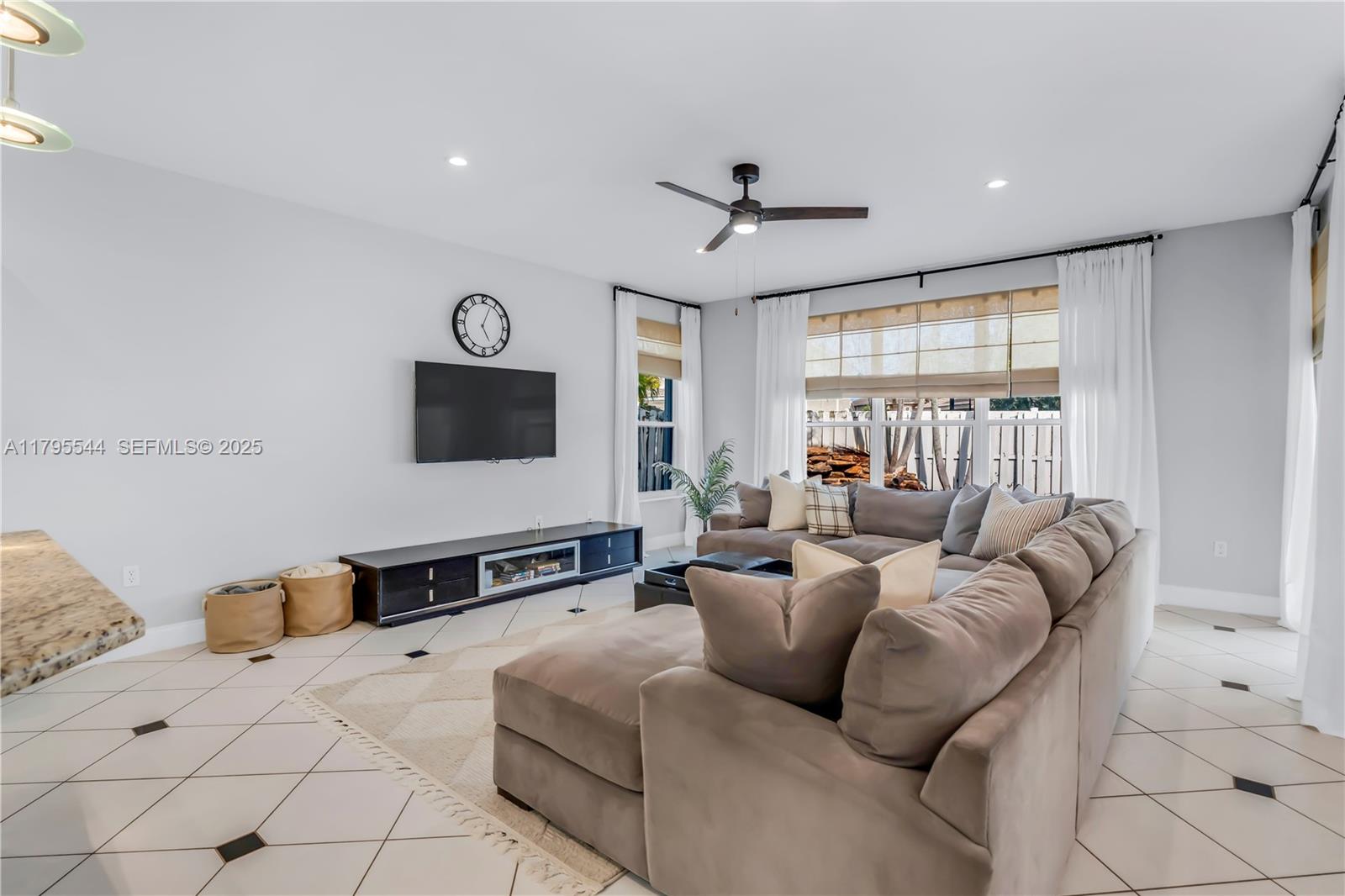 15862 Southwest 24th Street Miramar, FL 33027 - Photo 17 of 61 a living room with furniture ceiling fan and a flat screen tv