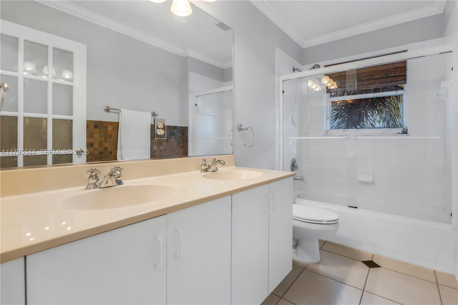 15862 Southwest 24th Street Miramar, FL 33027 - Photo 30 of 61 a bathroom with a double vanity sink toilet and shower