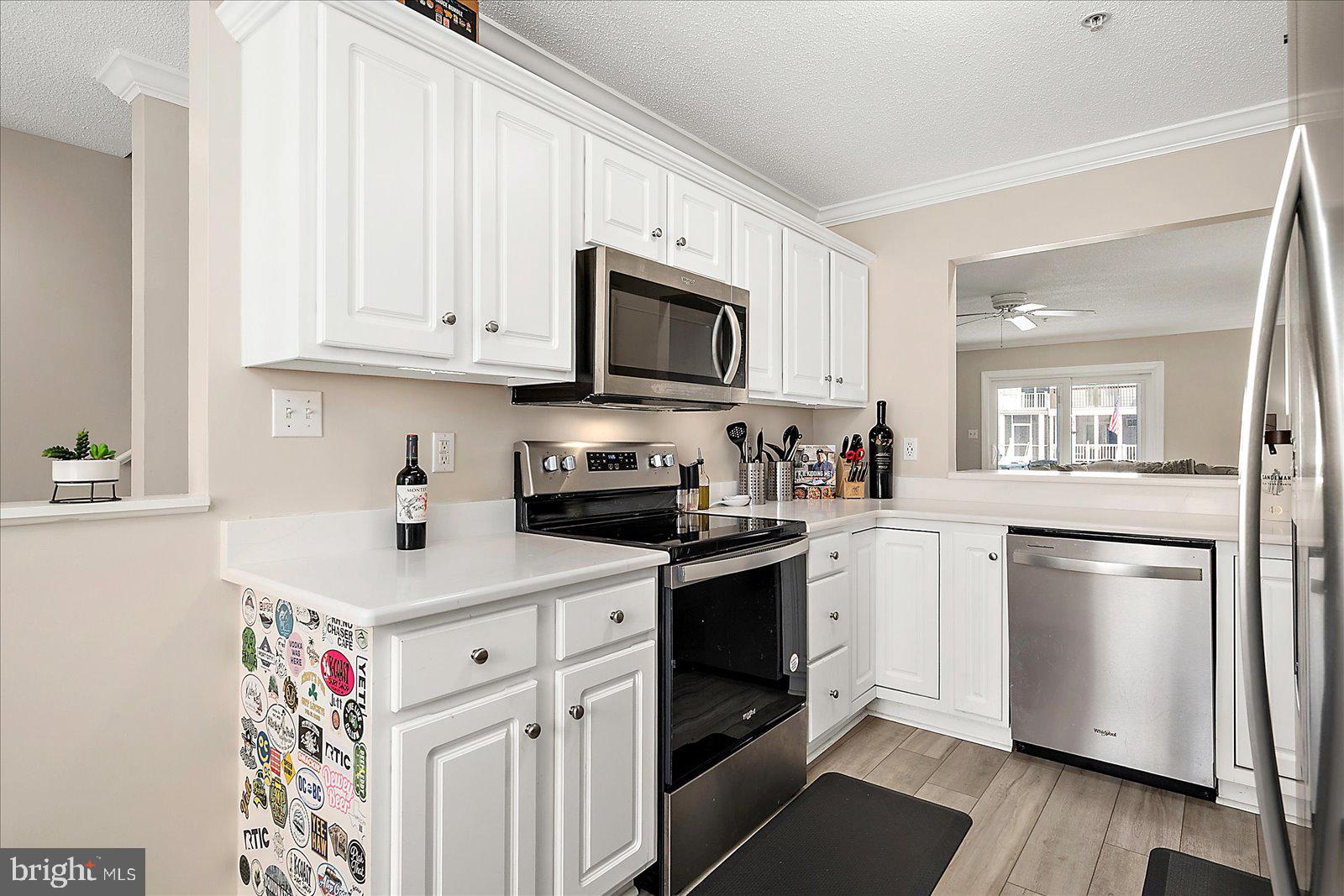 712 Bradley Road, Unit E Ocean City, MD 21842 - Photo 12 of 48 a kitchen with a sink stove and white cabinets