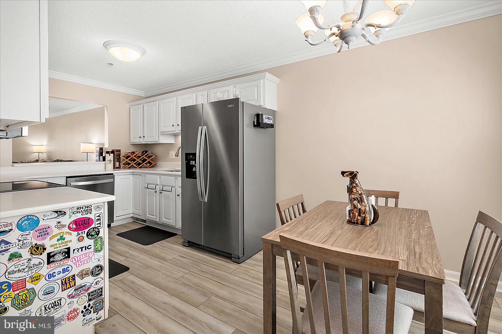 712 Bradley Road, Unit E Ocean City, MD 21842 - Photo 17 of 48 a kitchen with stainless steel appliances a refrigerator and a wooden floor