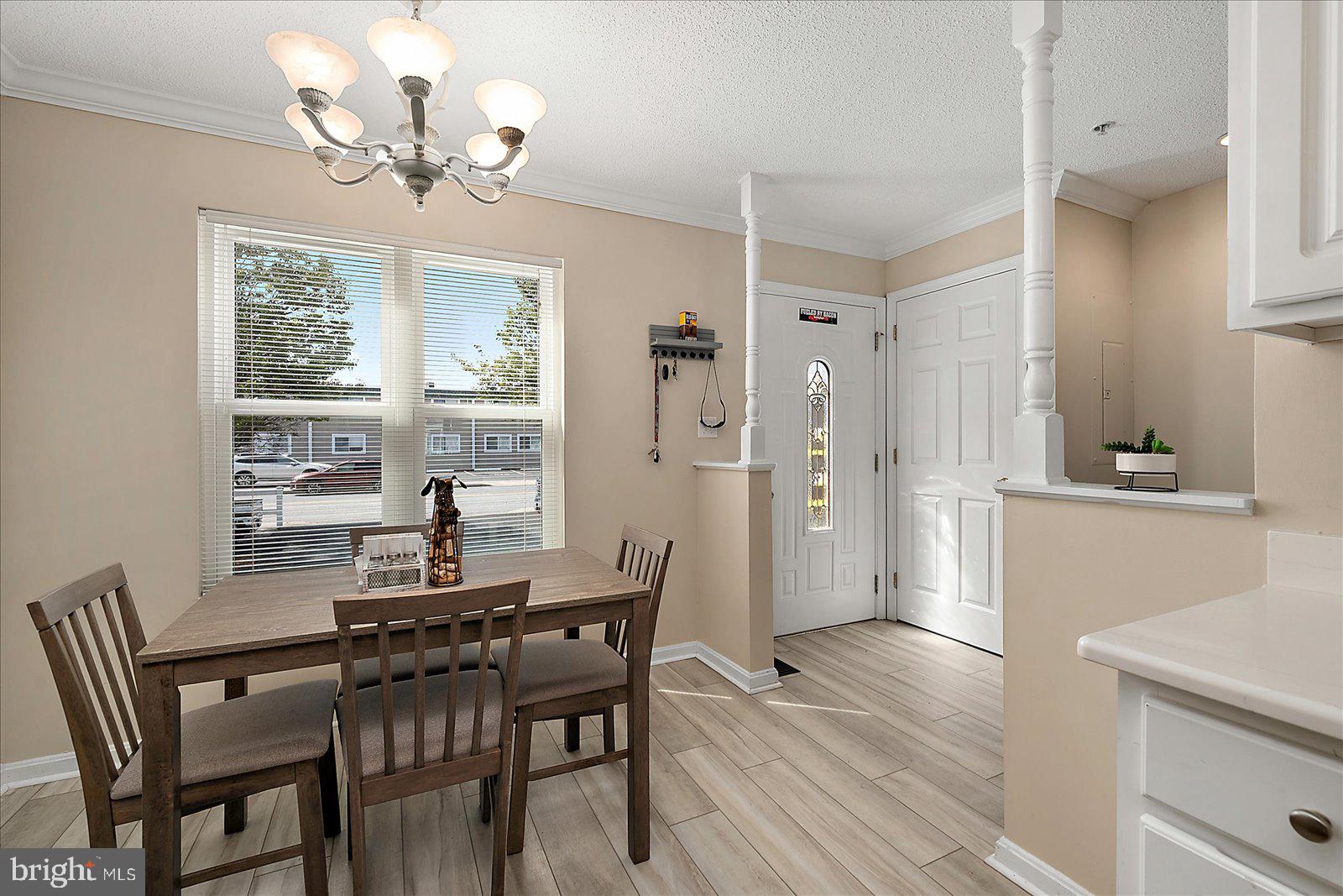 712 Bradley Road, Unit E Ocean City, MD 21842 - Photo 18 of 48 a view of a dining room with furniture a chandelier and wooden floor