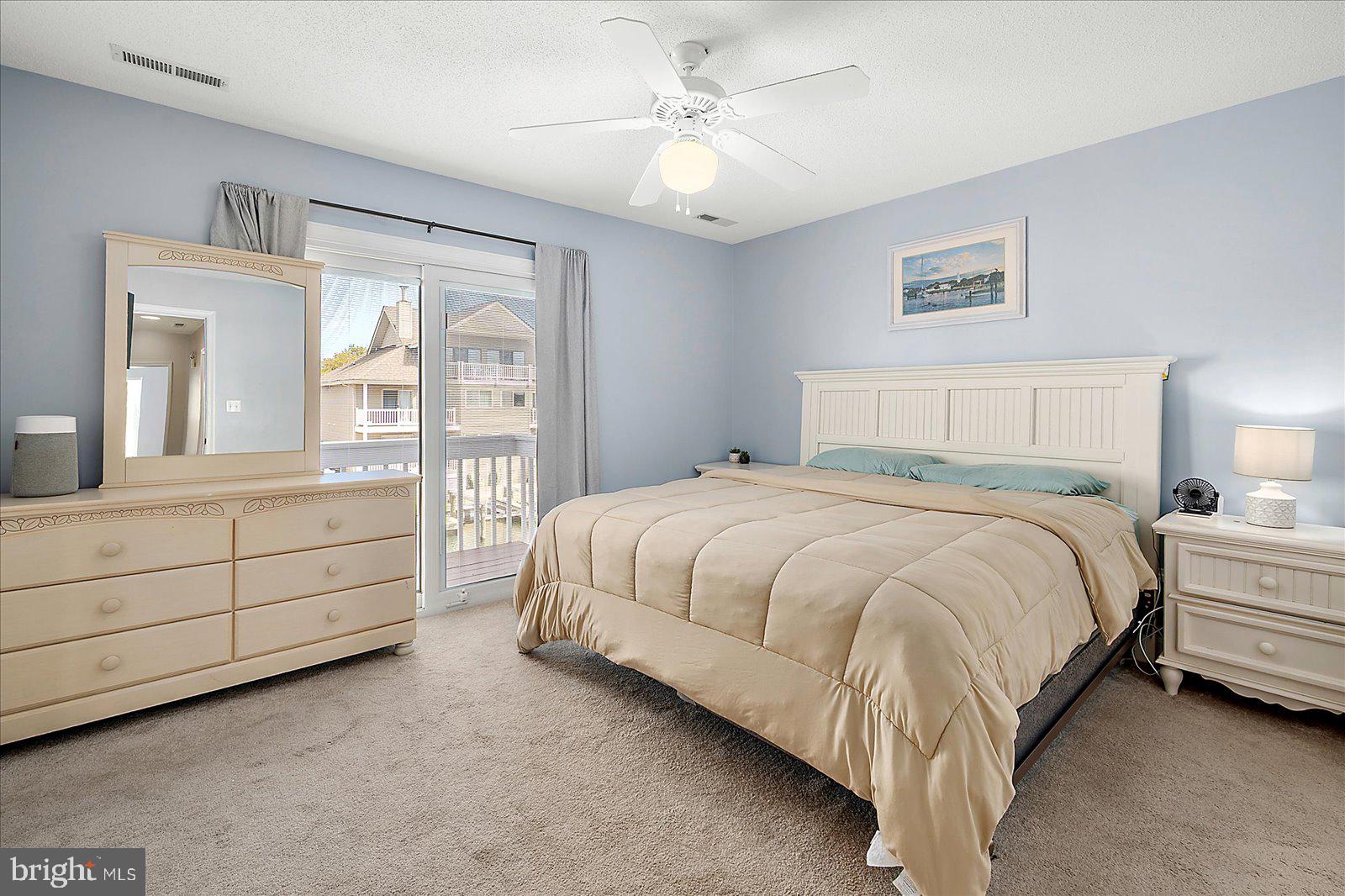 712 Bradley Road, Unit E Ocean City, MD 21842 - Photo 21 of 48 a spacious bedroom with a bed and a chandelier