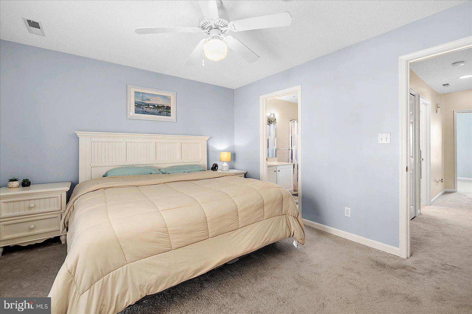 712 Bradley Road, Unit E Ocean City, MD 21842 - Photo 24 of 48 a bedroom with a bed and a chandelier