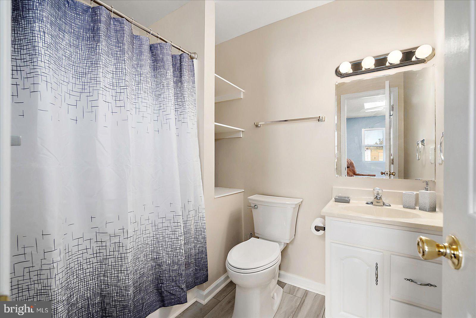 712 Bradley Road, Unit E Ocean City, MD 21842 - Photo 33 of 48 a bathroom with a sink a toilet and shower curtain