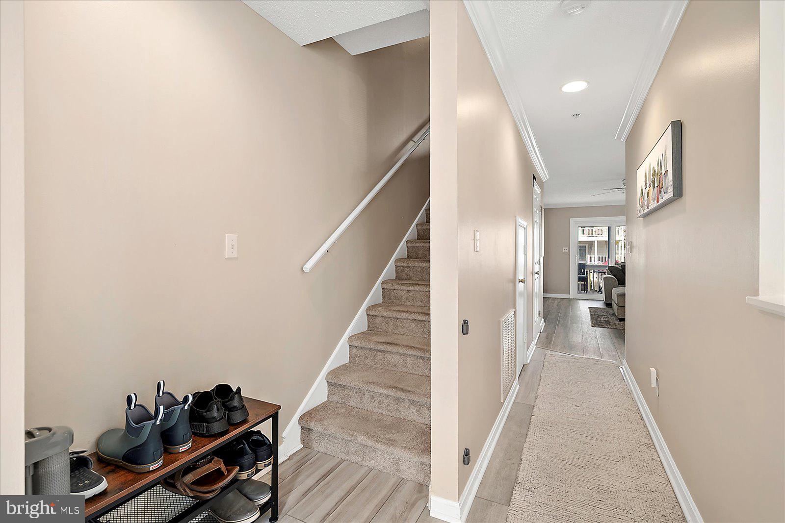 712 Bradley Road, Unit E Ocean City, MD 21842 - Photo 5 of 48 a view of a hallway with wooden floor and staircase