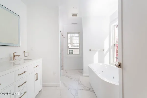 a bathroom with a tub sink and mirror