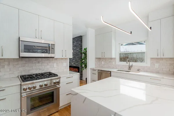 a kitchen with granite countertop a sink stove and cabinets