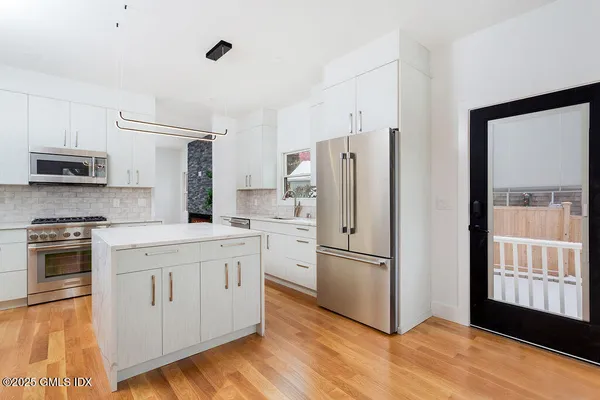 a kitchen with stainless steel appliances a refrigerator sink and microwave