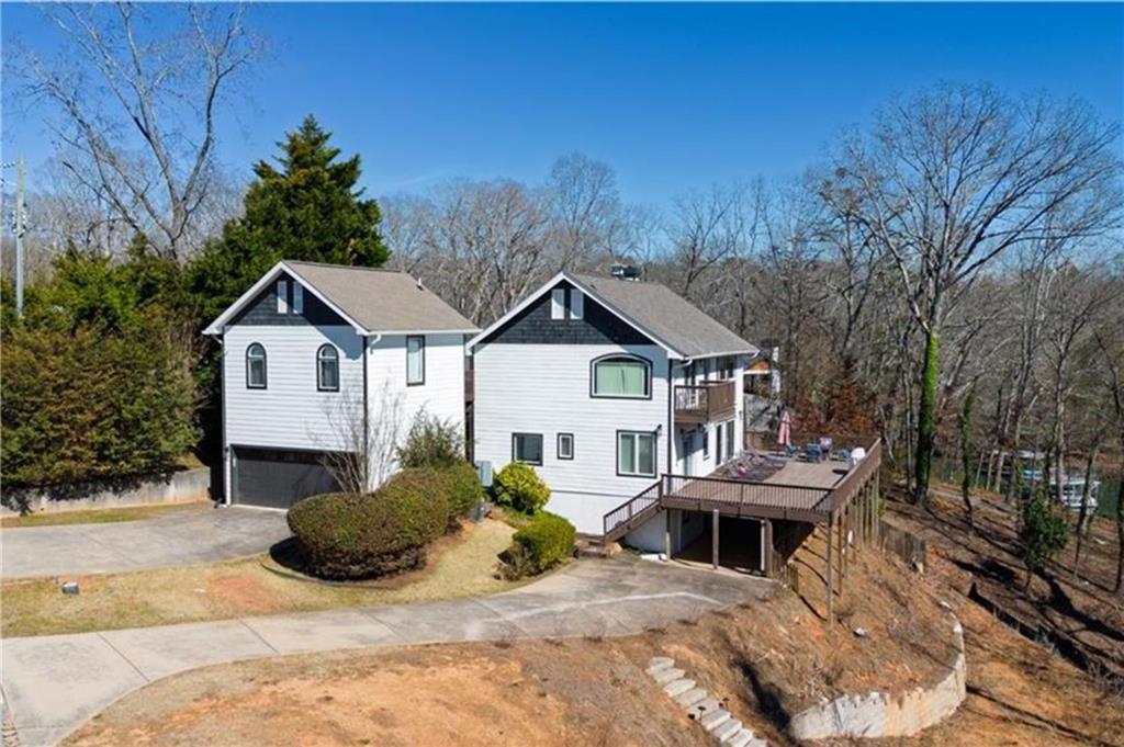 5997 Warpath Road Flowery Branch, GA 30542 - Photo 2 of 76 a view of a house with a yard and large trees