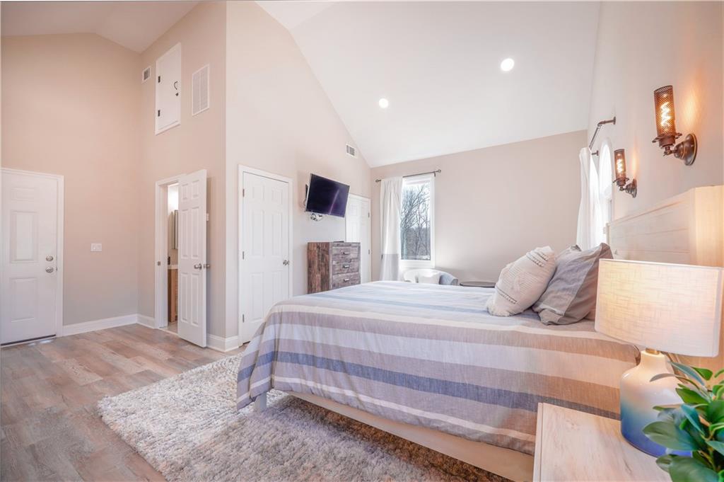 5997 Warpath Road Flowery Branch, GA 30542 - Photo 46 of 76 a bedroom with a large bed and a flat tv screen