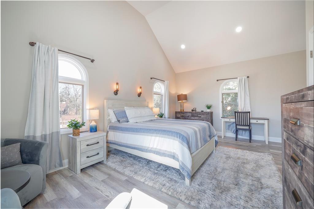 5997 Warpath Road Flowery Branch, GA 30542 - Photo 47 of 76 a spacious bedroom with a bed and a couch